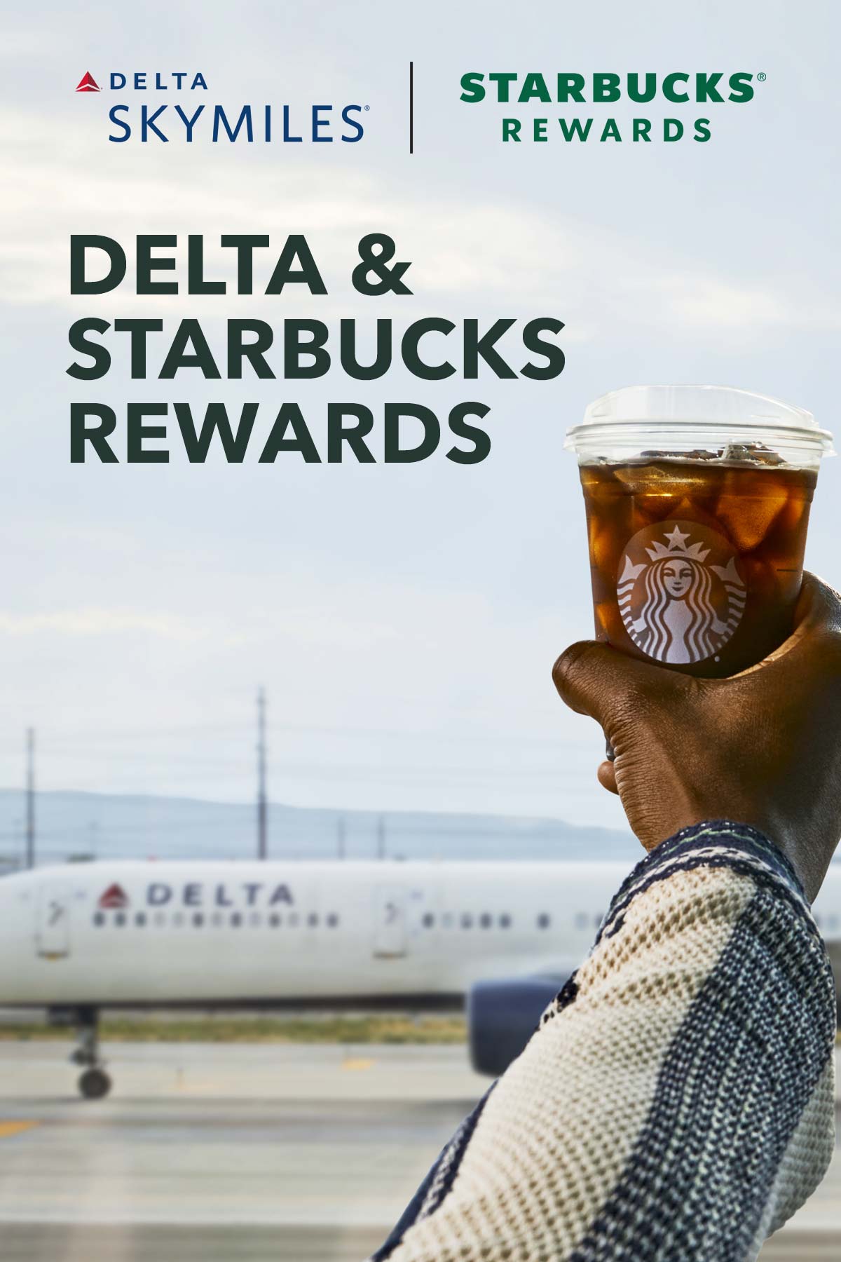 Delta en Starbucks Rewards tekst op foto van hand met Starbucks ijskoffie voor een Delta-vliegtuig.