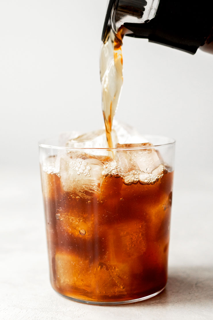 Cold brew koffie inschenken in een glas gevuld met ijs.