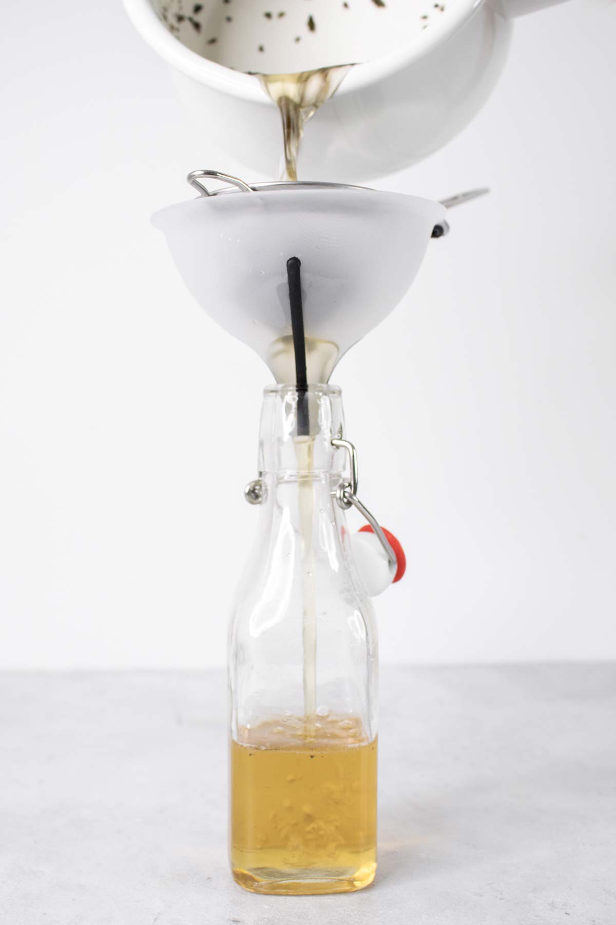 Munt eenvoudige siroop in een glazen fles uit een pan gieten.