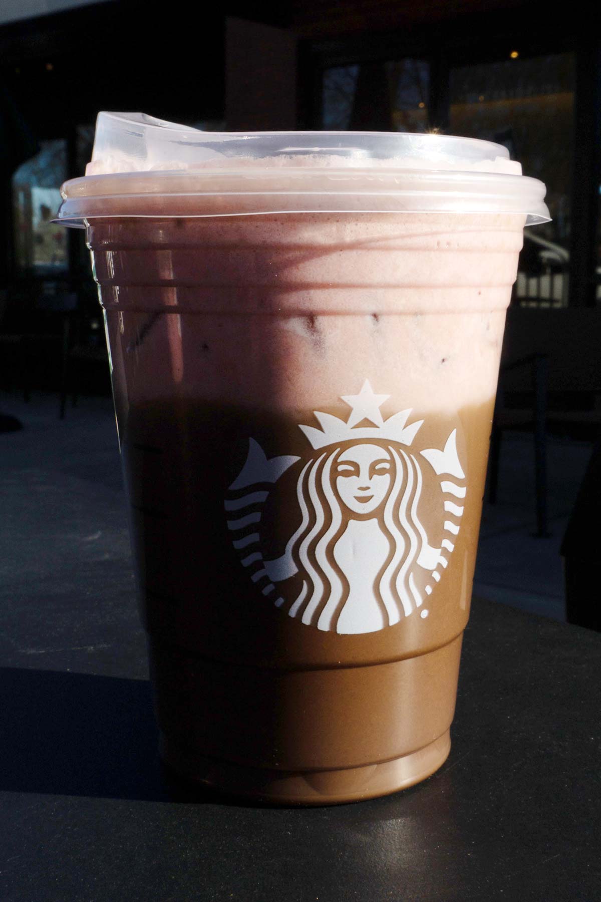 Starbucks gelaagde mokka en aardbeiendrank in een beker met een deksel.