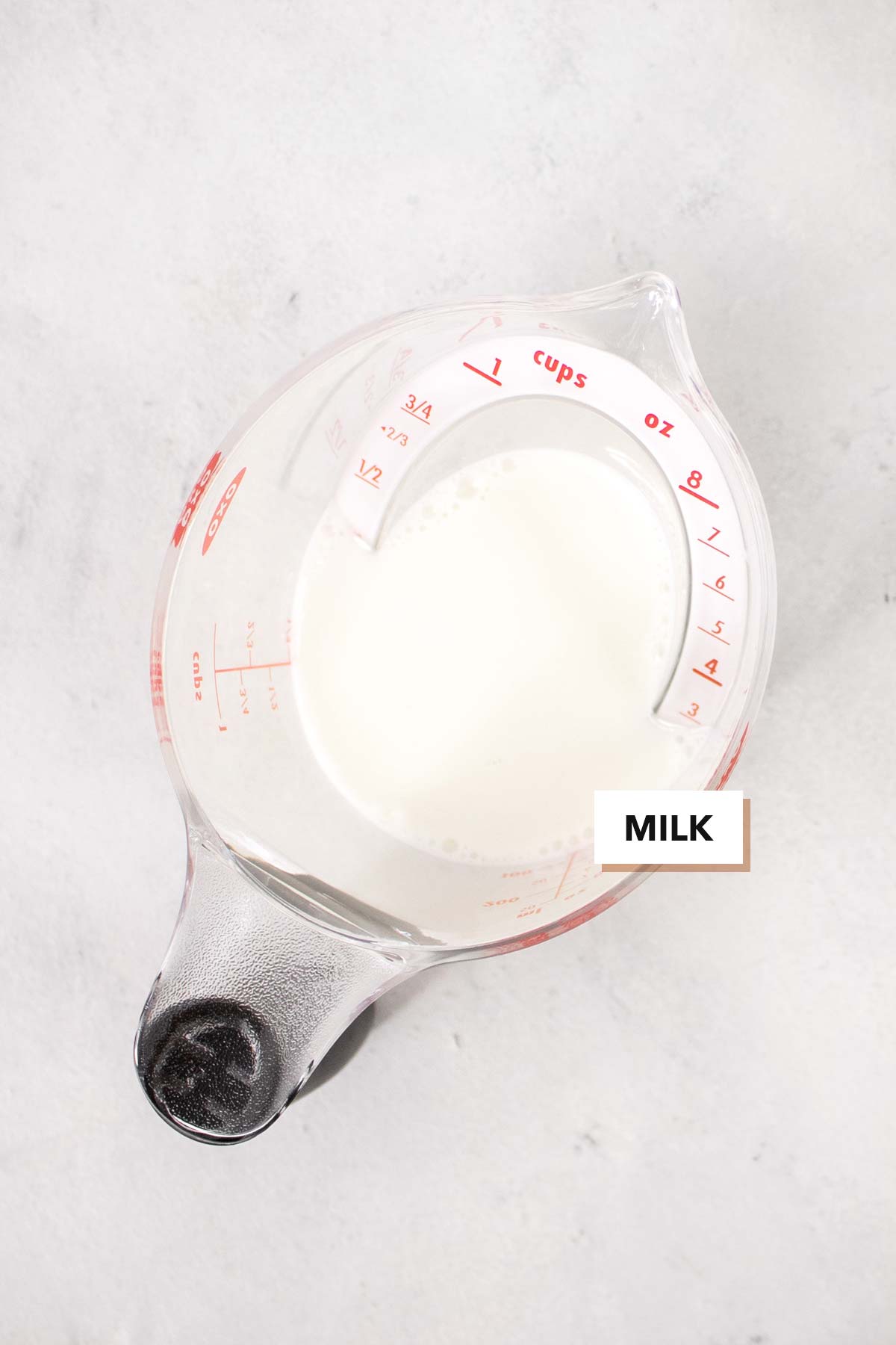 Melk in een maatbeker.