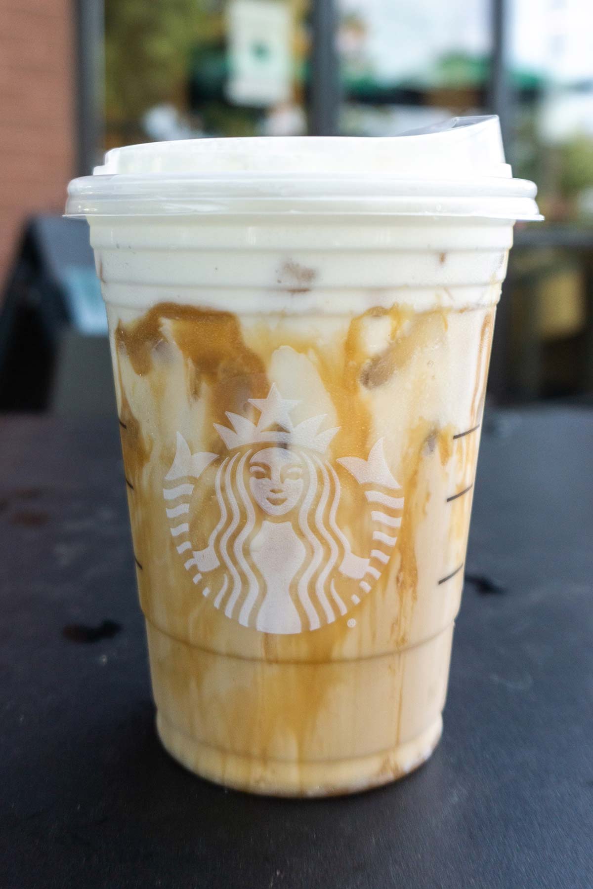Iced White Mocha met Sweet Cream Foam met extra karamel motregen Starbucks drankje in een kopje.